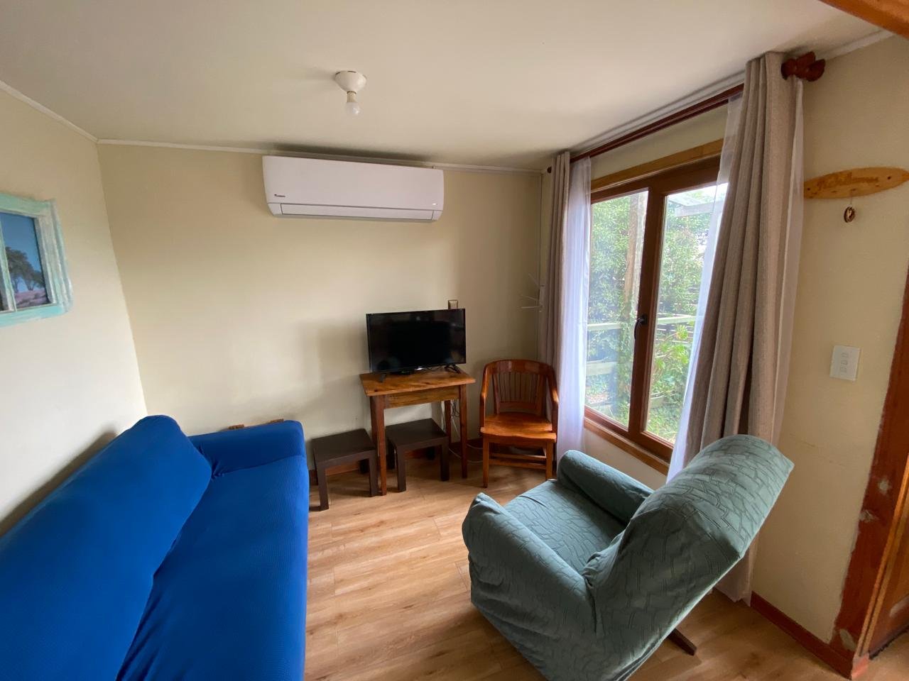 Living con sofá, sillón, TV y climatización